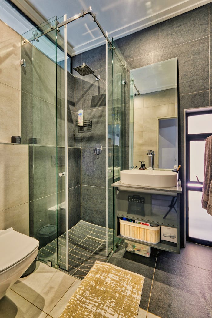 Stylish bathroom interior with glass shower, contemporary sink, and sleek design elements.